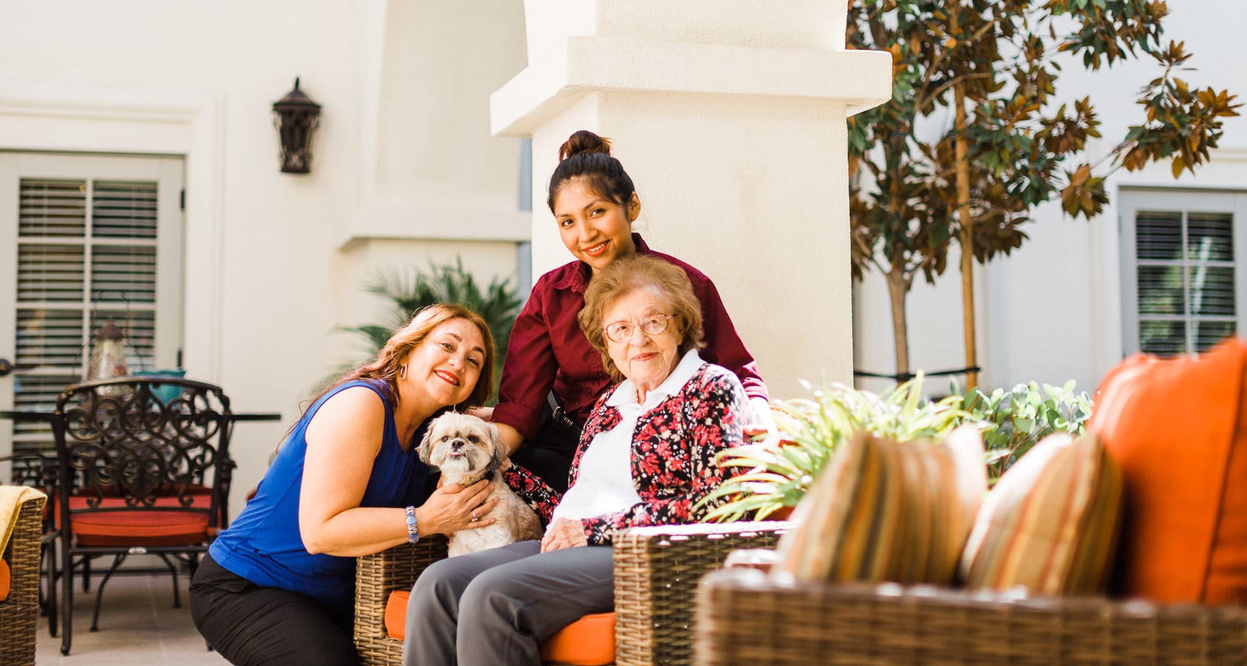 two team members with dog and resident at The Kensington assisted living and memory care community
