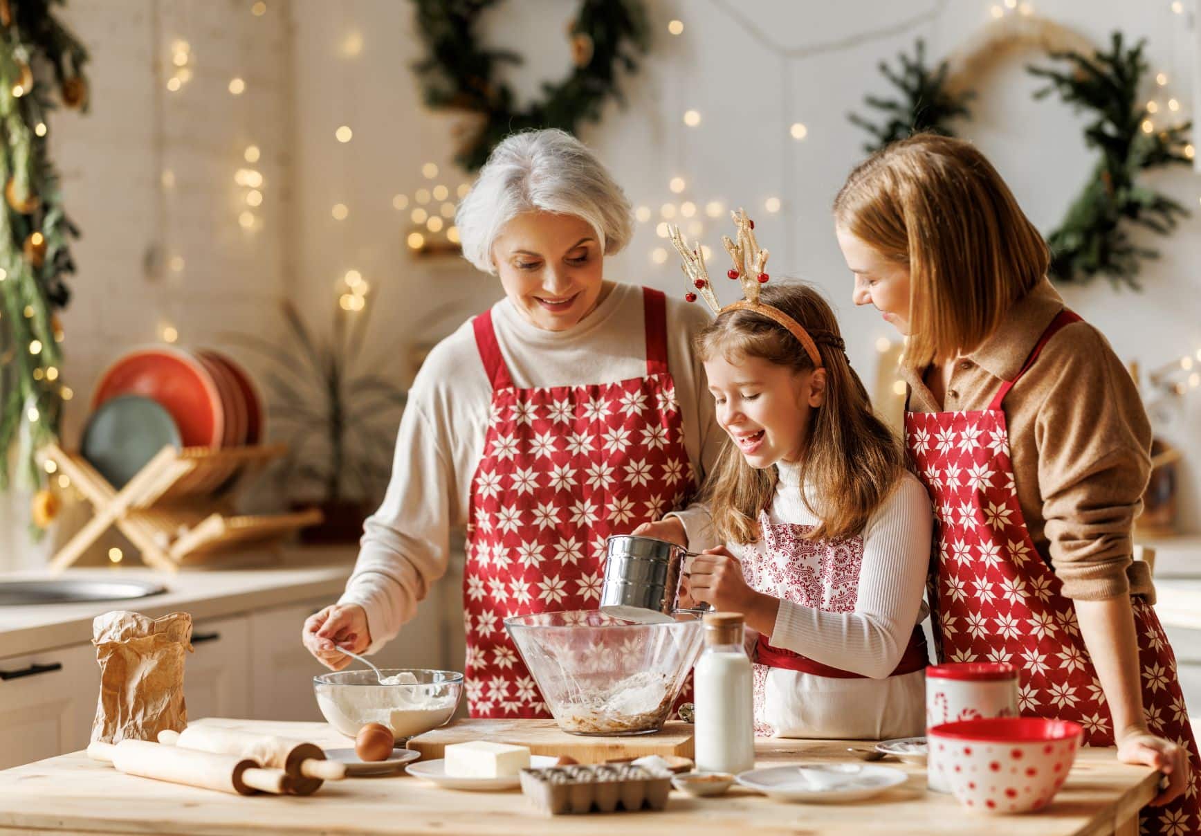 old woman, adult woman, and young girl making cookies together