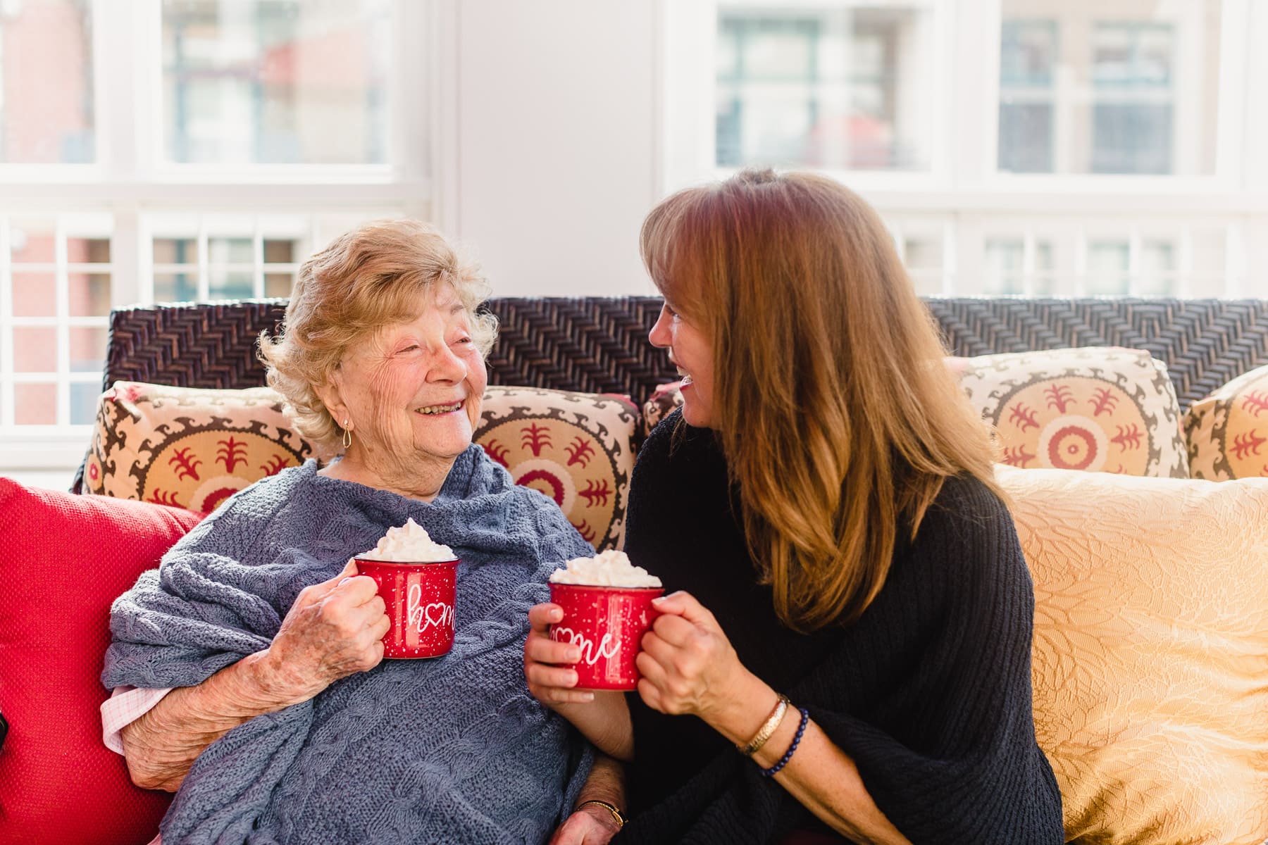 elderly women and caregiver enjoying coffee