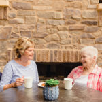 elderly resident and family member having coffee