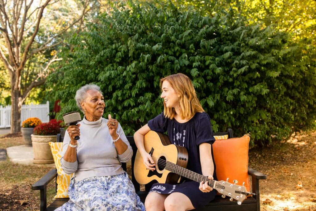 senior woman singing with music therapist outdoors summer fun