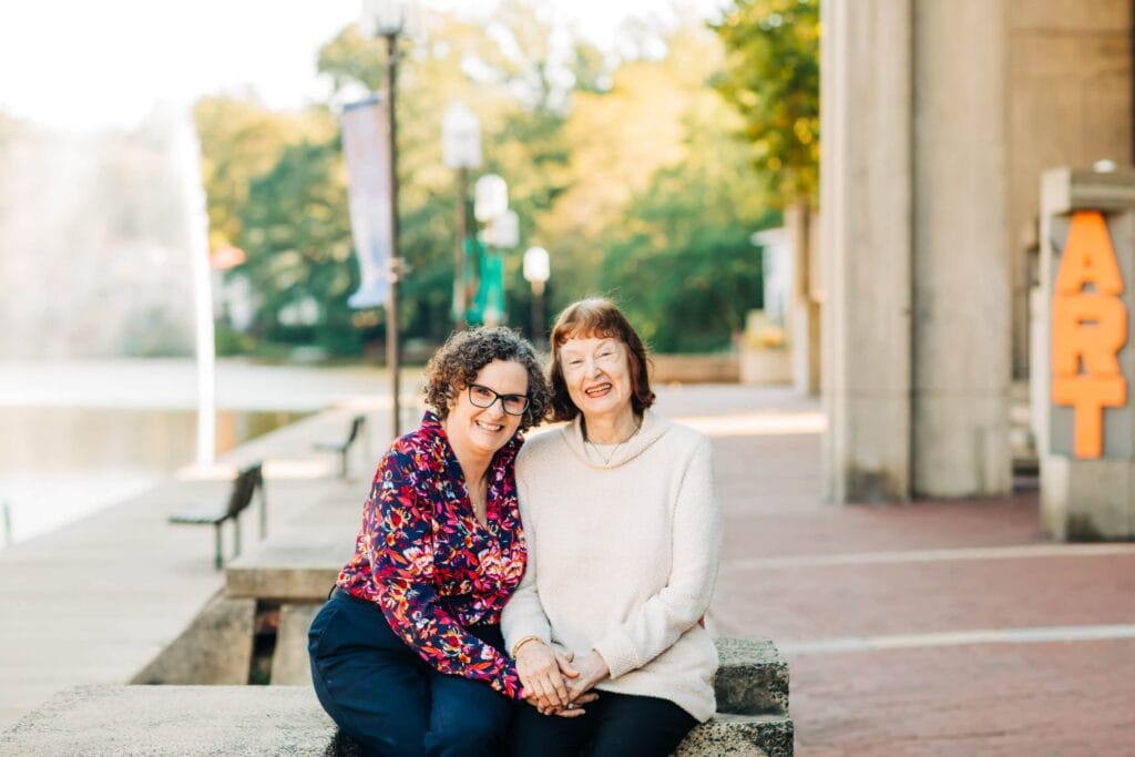 elderly woman and adult woman sitting on bench