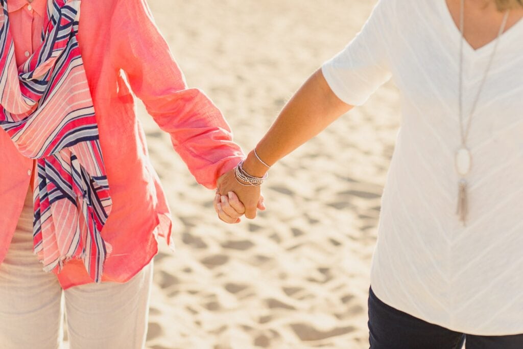 elderly woman and adult woman holding hands