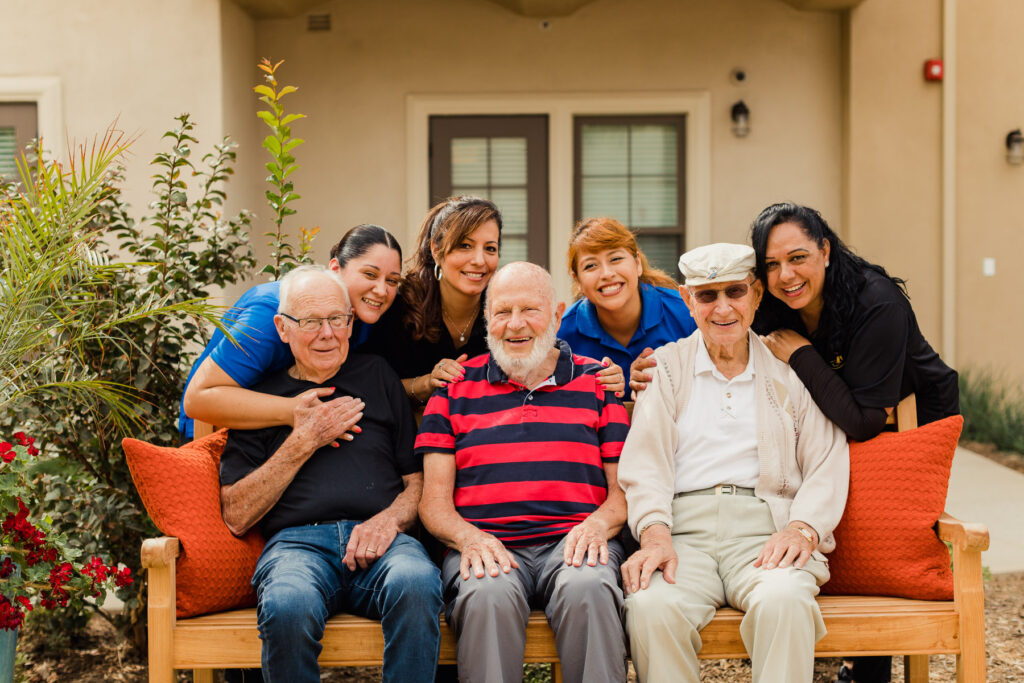 A group of people sitting on a bench with an elderly man.