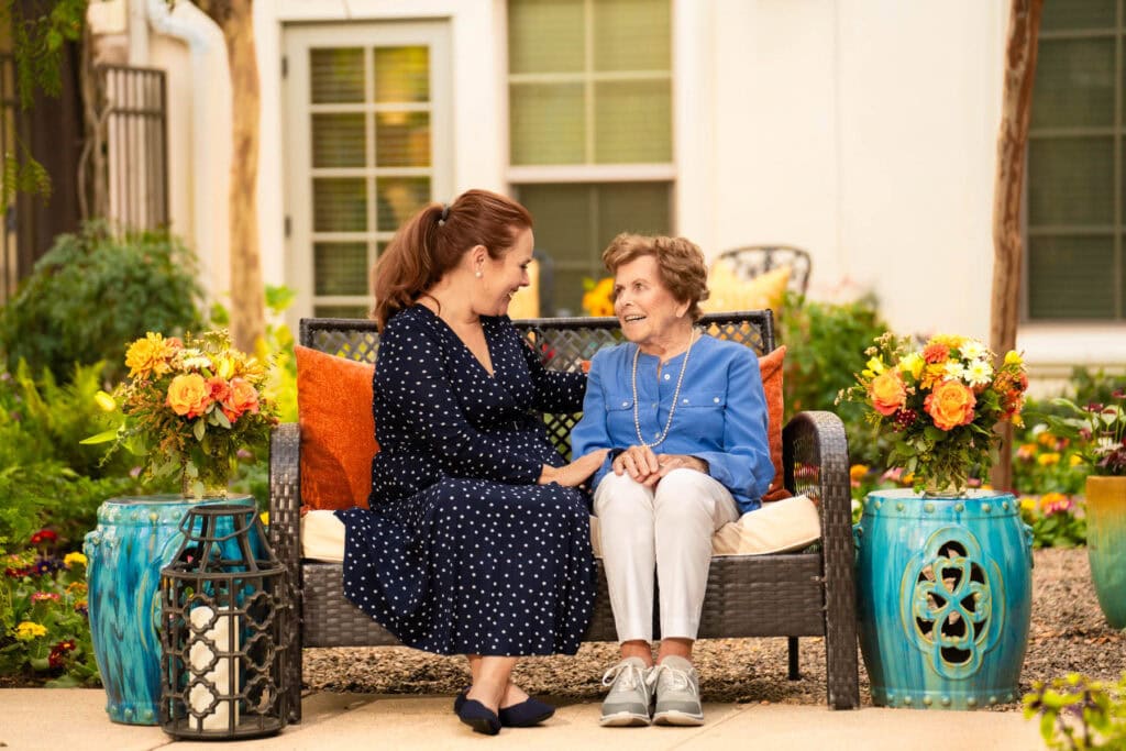 woman sitting with older woman on bench
