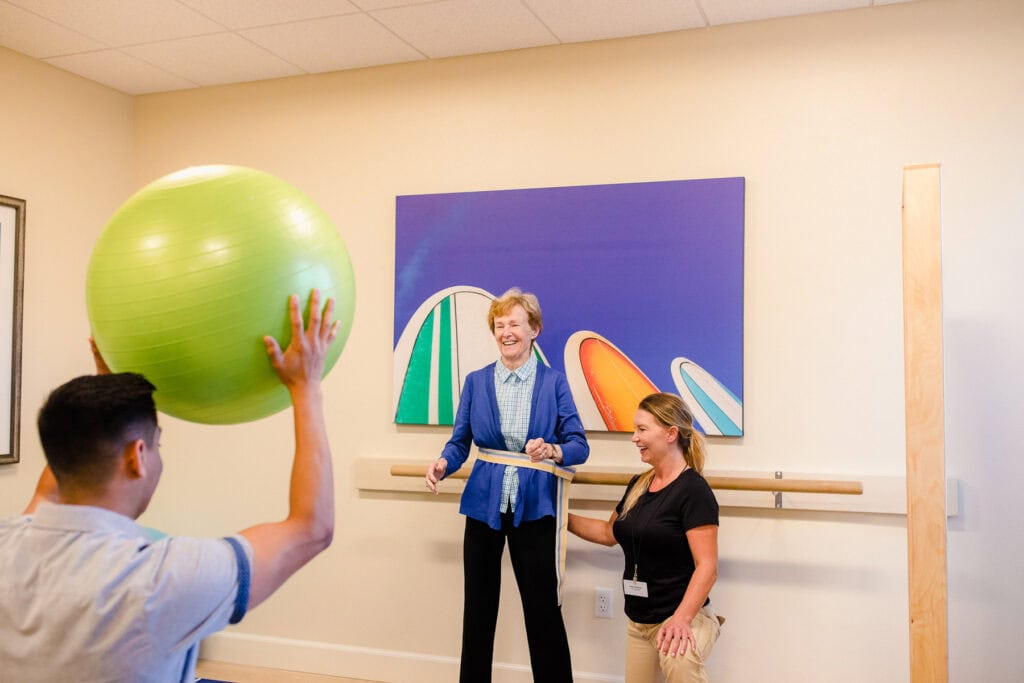 physical therapists assisting older woman