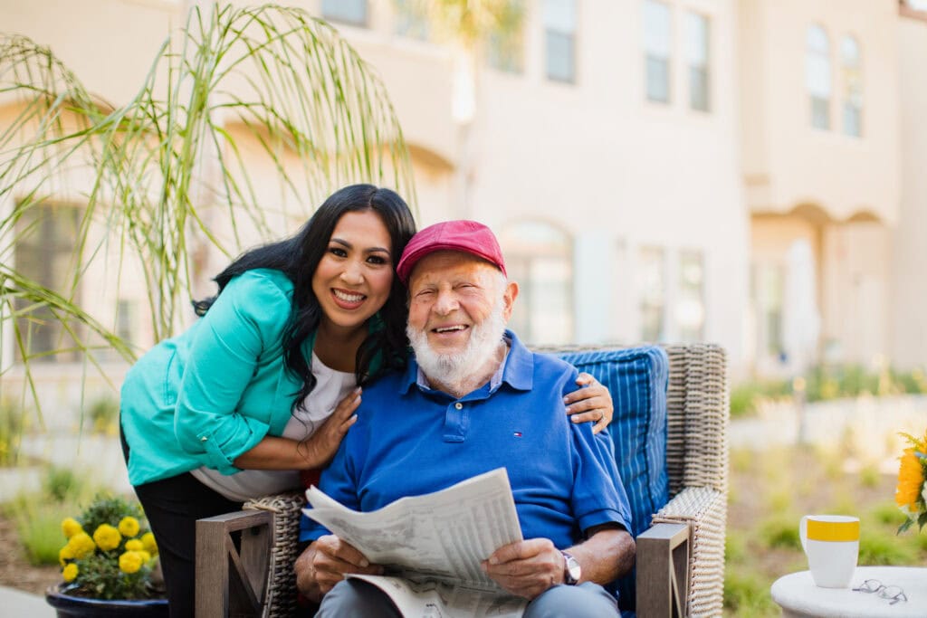 woman sitting with old man holding newspaper