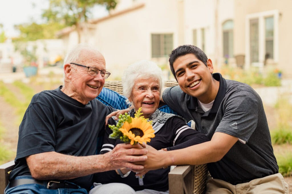 older couple and young man with flower
